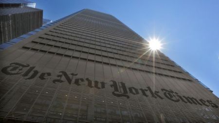 FILE PHOTO: The sun peaks over the New York Times Building in New York