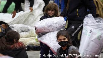 Πρόσφυγες παίρνουν κουβέρτες για να ζεσταθούν